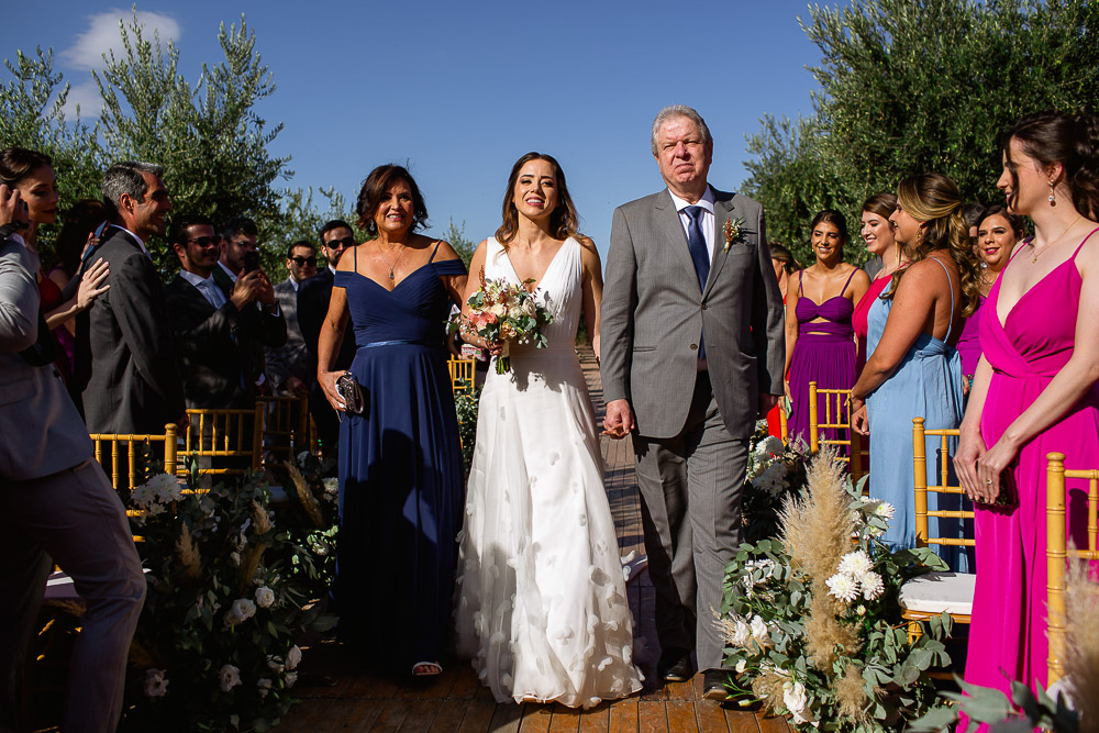 noiva entra com seus pais para o casamento entre os vinhedos na vinícola vistalba em mendoza