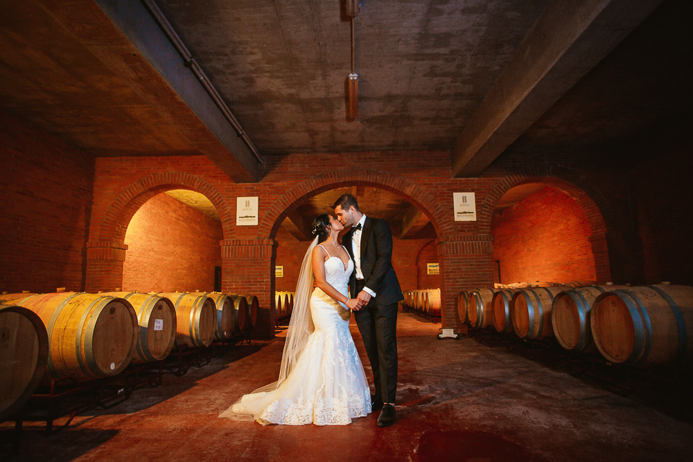 noivos se beijam em uma adega de uma vinícola de mendoza