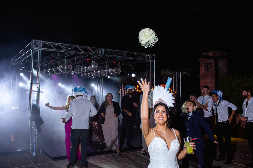 noiva joga seu buquê de noiva em seu casamento em um armazém em mendoza